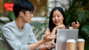 Pebisnis pemula sedang membuka laptop untuk mempelajari istilah digital marketing dasar