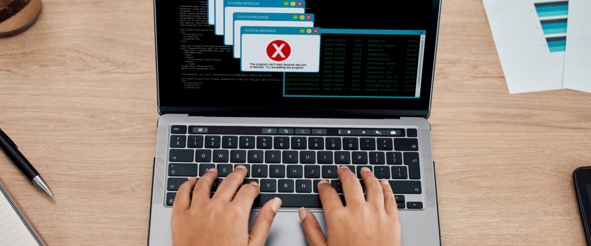 Tim IT sedang memeriksa error pada website di layar laptop 